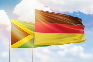 Sunny blue sky and flags of germany and jamaica
