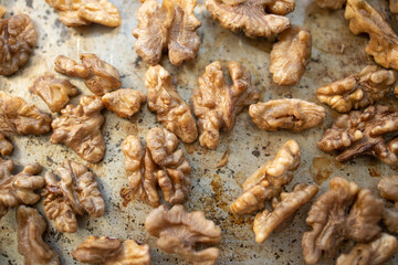 Roasted walnut lies on a metal baking sheet. Protein, healthy nuts, shortage of walnuts, more expensive snacks.
