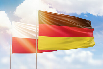 Sunny blue sky and flags of germany and poland