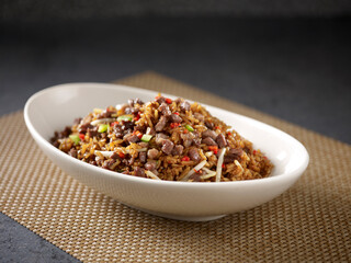 Fried Rice with Beef Cubes in Black Pepper Sauce served in a dish isolated on cutting board side view on dark background