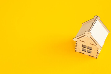 Mini wooden house on yellow background, Residence and House Loan Concept.