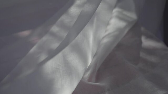 the shadows of the trees dancing on the swaying cotton translucent white tulle