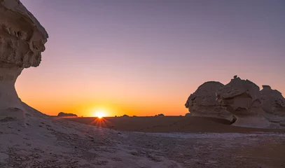 Zelfklevend Fotobehang sunrise in the white desert with the sun coming up behind the rock formations in Egypt © Simona