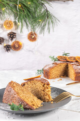 Obraz na płótnie Canvas Christmas orange and spice cake. Decorated with dried oranges on kitchen countertop