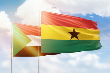 Sunny blue sky and flags of ghana and sudan