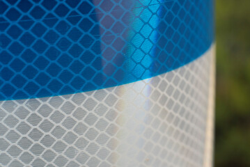 the reflecting surface of a blue and white striped traffic pole
