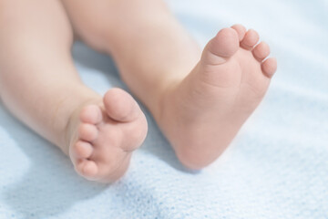 Obraz na płótnie Canvas baby legs lie on a blue blanket. Baby health. Leg motor skills