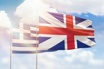 Sunny blue sky and flags of great britain and greece