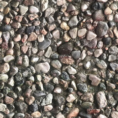 Seamless repeat texture. Pebbles glued to wall in various colors.