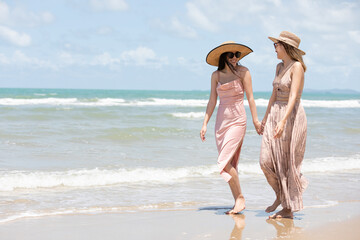 romantic young lesbian couples in love and walking together on the beach