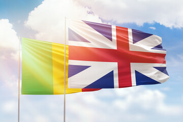 Sunny blue sky and flags of great britain and mali