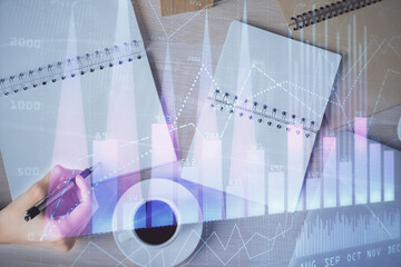 Multi exposure of woman's hands making notes with forex graph hologram. Concept of technical analysis.
