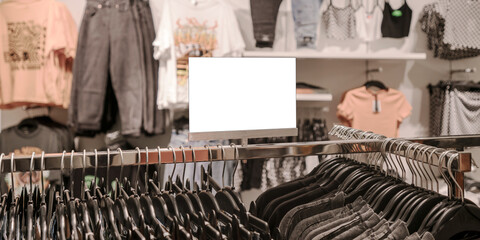 Blank white price tag stands on metal rack in city mall clothes department. Sale and discount concept.