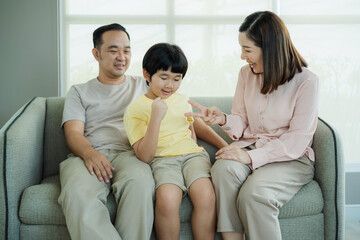 Smiling young parents and their child are very happy, Mum and dad and boys laughing and hugging. Happy family