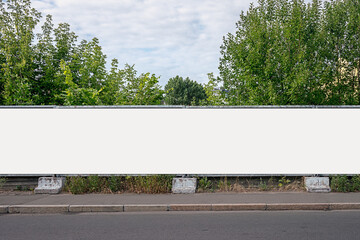 Advertisement long empty banner mounted on cement fence outdoor. Construction industry and...