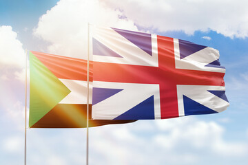 Sunny blue sky and flags of great britain and sudan