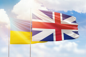 Sunny blue sky and flags of great britain and ukraine