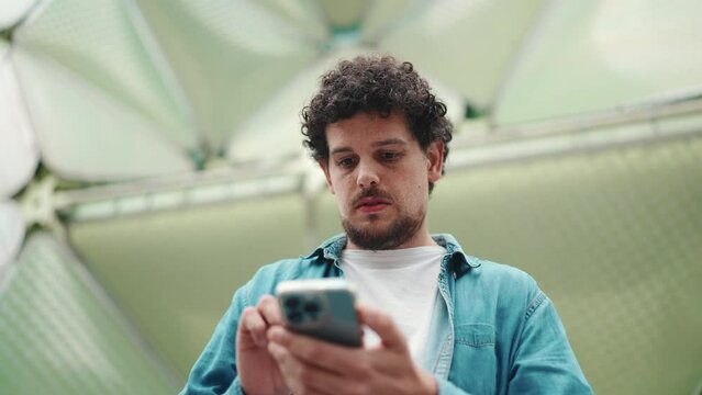 Close-up, man looks at google map on mobile phone and looks around on modern city background