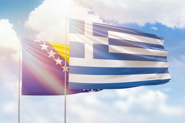 Sunny blue sky and flags of greece and bosnia