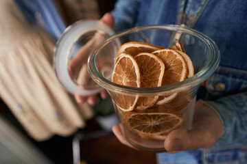 Man carrying pot with candied orange indoors