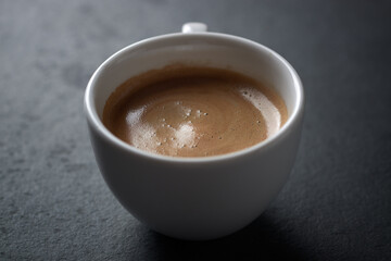 Cup of coffee on dark stone background. Close up. Copy space.