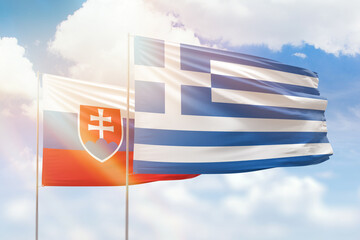 Sunny blue sky and flags of greece and slovakia