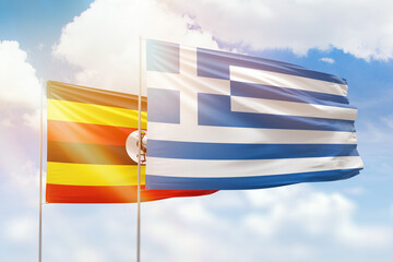 Sunny blue sky and flags of greece and uganda