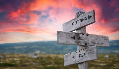 cutting all ties text quote caption on wooden signpost outdoors in nature with dramatic sunset skies. Panorama crop. Relation concept.