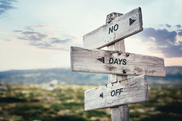 no days off text quote caption on wooden signpost outdoors in nature. Stock sign words theme.