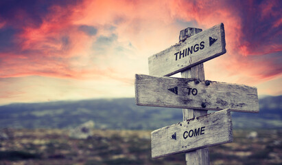 things to come text quote caption on wooden signpost outdoors in nature with dramatic sunset skies. Panorama crop. future concept. - obrazy, fototapety, plakaty