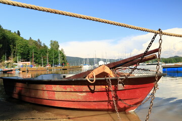 Moored boat with life jacket, oars and a net for catching fish. Zacumowana łódź z kamizelką ratunkową, wiosłami i siatką do połowu ryb.
Jezioro Solińskie w Bieszczadach. - obrazy, fototapety, plakaty