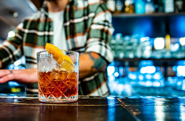 bartender making glass negroni cocktail in bar