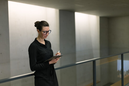 Business woman using tablet pc in minimalist office interior