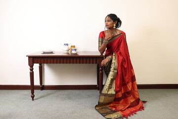Indian woman wearing red orange saree jewellery choker set necklace jhumka earring maang tikka...