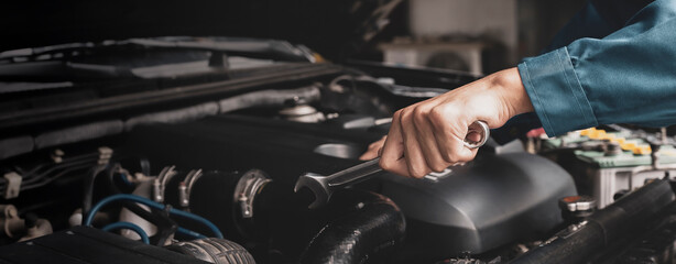 Mechanic works on the engine of the car e in the garage,car repair service.