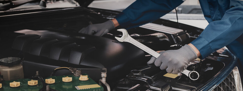 Mechanic works on the engine of the car e in the garage,car repair service.