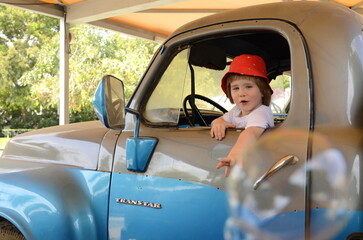 Ramla. Israel. Truck and transport museum. A little boy is driving a vintage Studebaker. Blue retro truck Studebaker transtar. 