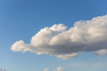 Naklejka na ściany i meble A cumulus cloud against a clear blue sky