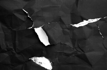 Black paper with white tears for the background. Crumpled paper texture with messy tears. 