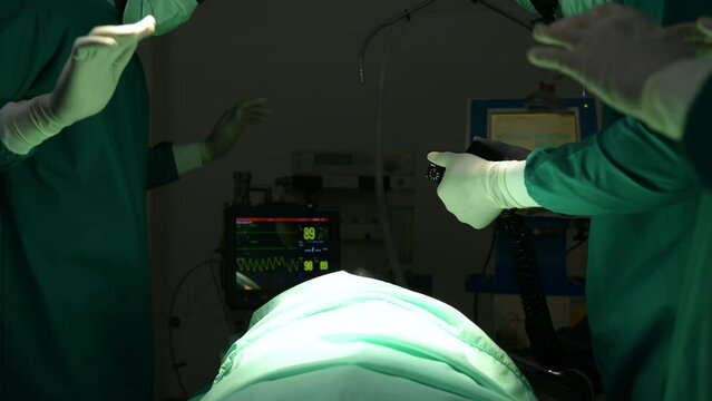 A team of doctors in the operating room performs CPR on a patient who is suffering from shock from heart failure.