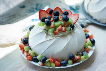 Pavlova cakes. Delicious meringue cake with fresh summer berries; strawberry, blueberry and kiwi, fill with fresh cream. Dessert for dinner. Summer’s dessert.