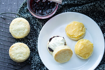 Scones. Top view of Cream Scones with homemade mixed berry jam and Clotted Cream are perfect combination for tea time. Traditional English Scones.