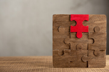 Creative idea and solve the problem concept. Teamwork success strategy - wooden puzzle on the grey background