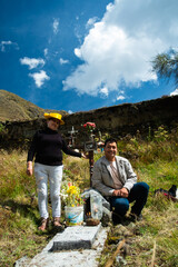 Married couple visiting their relative, in a rural cemetery in the Peruvian Andes