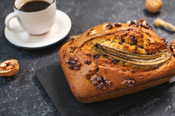 Banana bread or cake with chocolate and walnuts with cup of coffee. Delicious homemade dessert or morning breakfast.