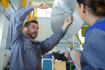 two engineers working on satellite disk