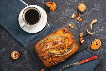 Banana bread or cake with chocolate and walnuts with cup of coffee. Delicious homemade dessert or morning breakfast.