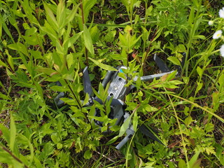 空撮中に草むらに墜落し破損したドローン
