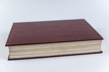 The large red book against a neutral background. Closed book with yellowed pages. Hardcover encyclopedia. Close-up. Selective Focus.