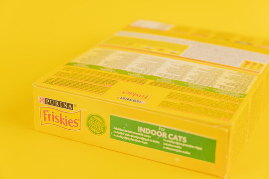 Purina Friskies cat food. Cardboard box with dry pelleted pet food. Yellow background. Selective focus. Ukraine, Mykolayiv - 05 25 2022